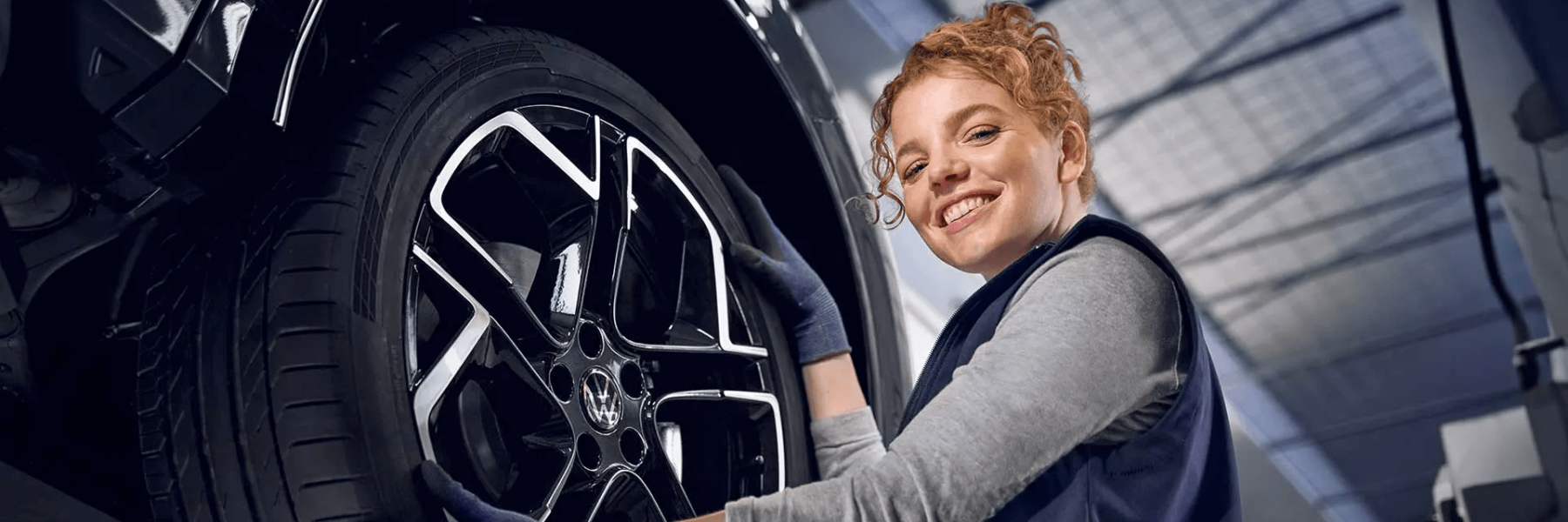 meccanico-ragazza-sorridente-gomma-auto-riparazione